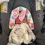 baby, newborn, sleeping, onesie, pink_bow, crown, car_seat, floral_pattern, gray_padding, warning_label, child, infant, cute, peaceful, indoor, soft, resting, small, adorable, headband