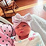 Jolene is registered to the contest to win money with this photo: newborn, baby, blanket, bow, headwear, polka_dot, pink, indoor, wooden_chair, floor, person, infant, wrapped, cute, portrait, handprint, calm, soft_lighting, holding, clothing