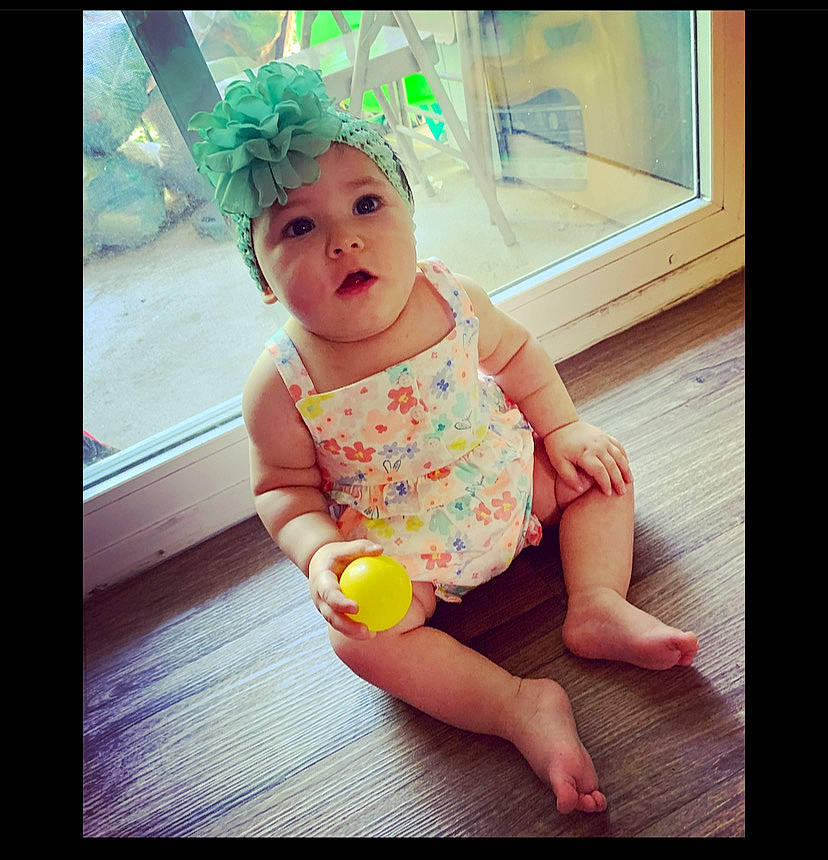 Gracelyn is registered to the contest to win money with this photo: baby, baby_toddler_clothing, barefoot, child, electronic_device, face, finger, floor, flooring, foot, fun, green, happy, head, headwear, human_leg, person, sleeve, thigh, thumb