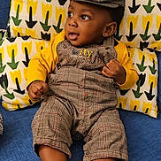 Mathis participe au concours pour gagner de l'argent avec cette photo : baby, child, infant, plaid_clothing, cap, yellow_socks, couch, pillows, patterned_pillow, blue_couch, indoors, portrait, cute, looking_away, fashion, sitting, soft_furniture, colorful, happy, young_child