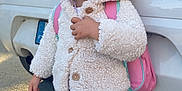 Kelly a rejoint le concours — aidez-le/la à gagner de superbes lots ! child, toddler, smiling, jacket, backpack, car, vehicle, road, outdoor, person, standing, clothing, hood, pants, footwear, daylight, cute, happy, portrait, casual