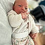Manon participe au concours pour gagner de l'argent avec cette photo : baby, infant, hand, knitted_sweater, floral_pants, cute, sleepy, person, child, newborn, cozy, soft_focus, indoor, couch, family, portrait, skin, fingers, holding, relax