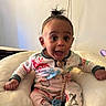 Kyrie joined the competition — help win amazing prizes! baby, child, pajamas, smiling, sitting, indoor, cushion, pillow, person, face, happy, cute, home, television, wall, cord, footwear, expression, infant, clothing