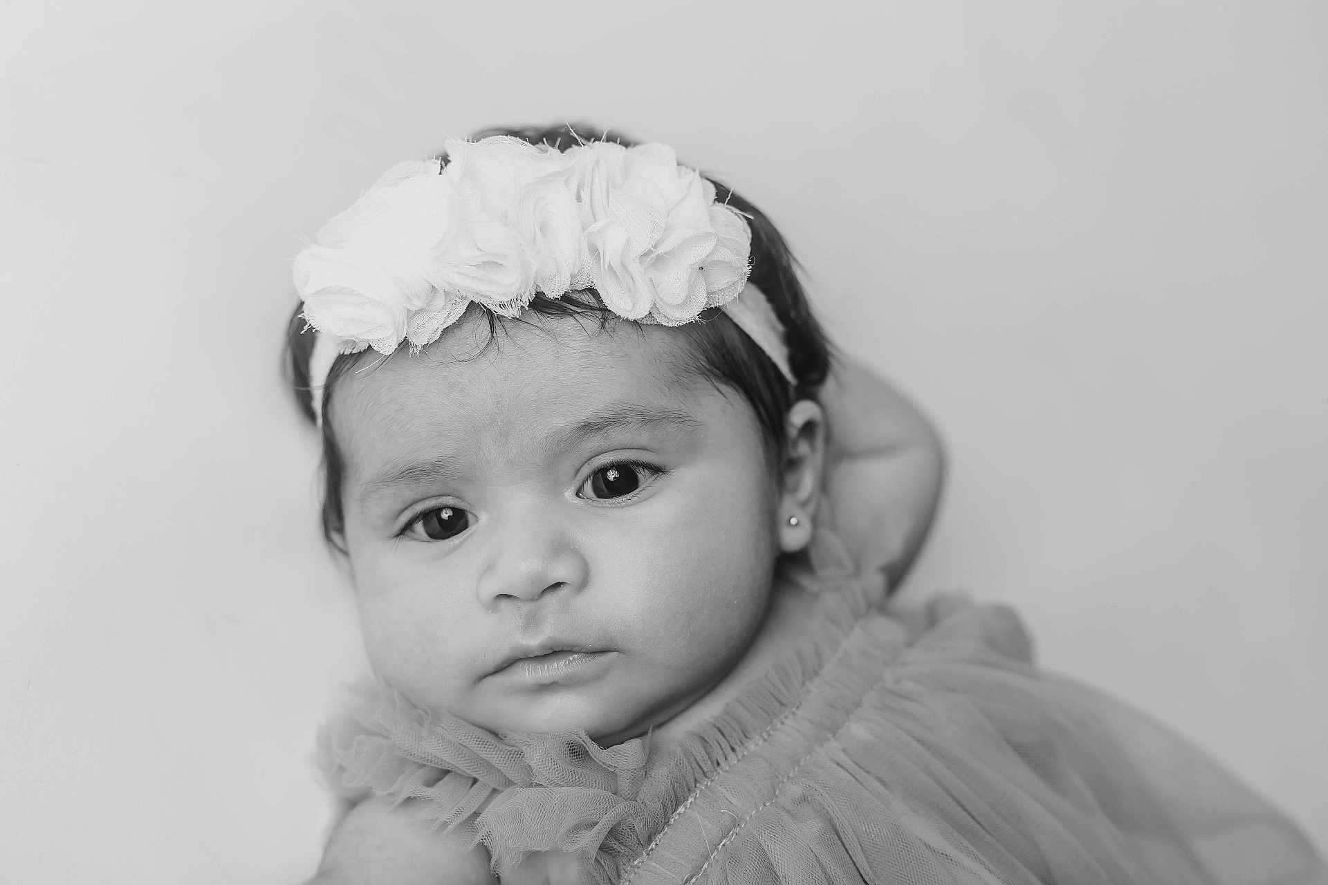 Rosita is registered to the contest to win money with this photo: baby, headband, flower, portrait, black_and_white, infant, dress, soft_focus, cute, child, close_up, face, young, adorable, studio, expression, person, young_child, fashion, candid