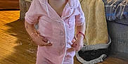 Anita joined the competition — help win amazing prizes! toddler, child, pajamas, pink_clothing, barefoot, wooden_floor, living_room, couch, blanket, pillow, indoor, person, furniture, home, curly_hair, expression, standing, cozy, casual, floor