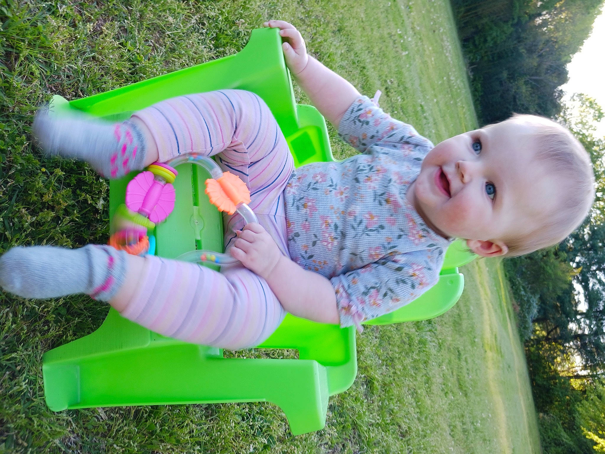 Nova is registered to the contest to win money with this photo: arm, baby_toddler_clothing, child, finger, fun, grass, hand, happy, human_body, joy, leg, leisure, mammal, people_in_nature, person, pink, plant, product, smile, toddler