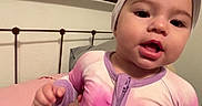 Sophia joined the competition — help win amazing prizes! toddler, child, bedroom, bed, headband, onesie, purple, pink, metal_bedframe, person, indoor, expression, young_child, sleepwear, blanket, hand, face, infant, home, cute