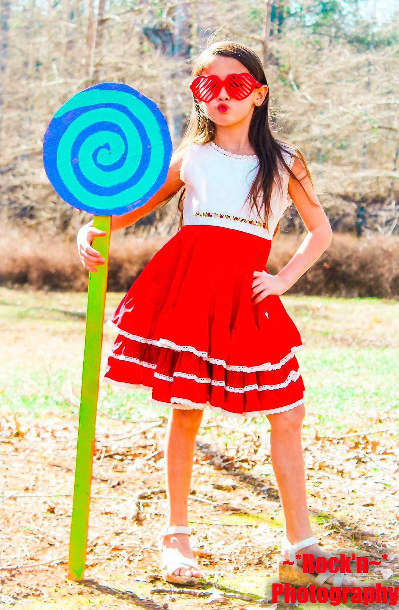 Makayla is registered to the contest to win money with this photo: child, child_model, clothing, costume, dress, fashion, fun, games, pattern, person, photo_shoot, photography, recreation, red, shorts, smile, spring, style, summer, vacation