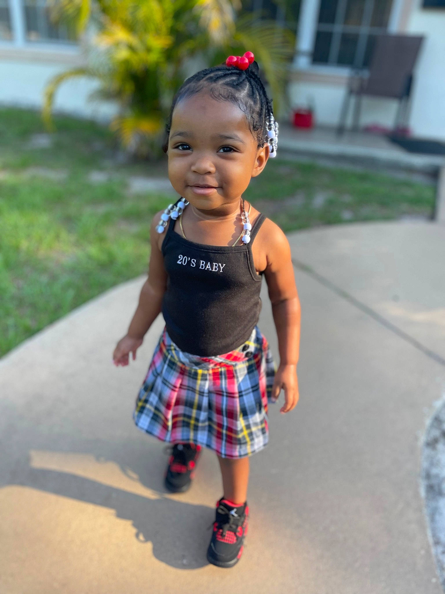Kylani is registered to the contest to win money with this photo: baby, baby_toddler_clothing, clothing, electric_blue, face, fashion_accessory, hair, hairstyle, head, jewellery, joy, pattern, person, pink, plaid, plant, sock, street_fashion, tartan, toddler