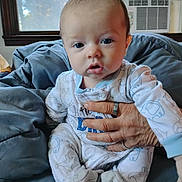 Kiah joined the competition — help win amazing prizes! baby, infant, pajamas, elephant_pattern, hand, adult_hand, blanket, window, air_conditioner, indoor, portrait, cute, child, soft_toys, footed_pajamas, blue, white, face, expression, cozy