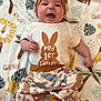 baby, infant, smiling, cute, animal_hat, onesie, pants, blanket, giraffe_pattern, leaf_pattern, lying_down, happy, child, face, headwear, foot, expression, indoors, soft_texture, playful