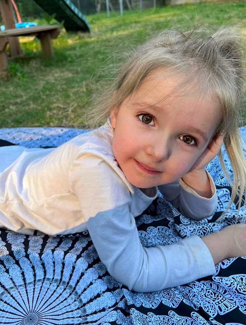 Cordelia is registered to the contest to win money with this photo: child, electric_blue, fun, grass, happy, iris, leisure, pattern, people_in_nature, person, plant, play, portrait_photography, recreation, sitting, smile, toddler, tree, vacation