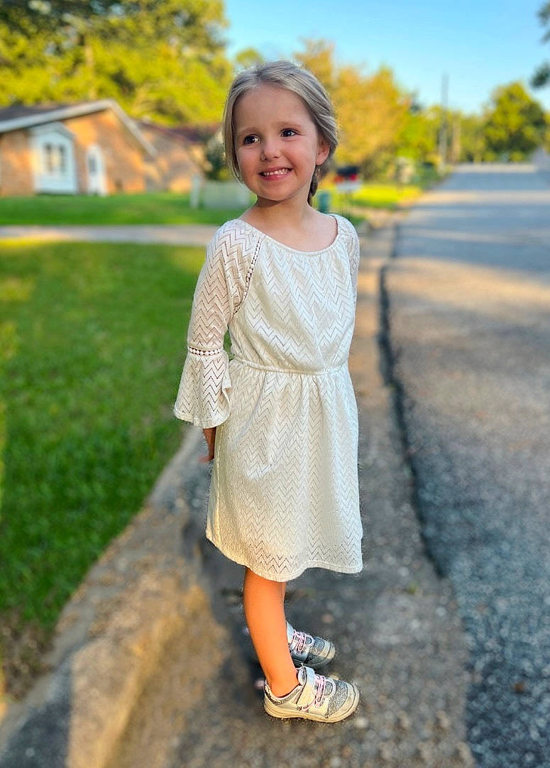 Cordelia is registered to the contest to win money with this photo: asphalt, blond, electric_blue, footwear, grass, hair, happy, joy, leisure, pattern, people_in_nature, person, plant, sandal, sky, sleeve, smile, summer, toddler, tree