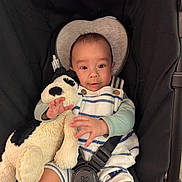 Leo joined the competition — help win amazing prizes! baby, infant, plush_toy, stroller, child, smiling, striped_clothing, soft_toy, seatbelt, cute, happy, portrait, indoor, baby_clothes, hand, face, head_support, comfort, toddler, person