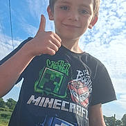 Mayron a rejoint le concours — aidez-le/la à gagner de superbes lots ! child, boy, smiling, thumbs_up, tshirt, minecraft, outdoor, sky, clouds, grass, fence, sunlight, casual_clothing, happy, portrait, daytime, nature, young, person, background