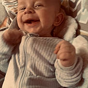 Zack joined the competition — help win amazing prizes! baby, infant, child, smiling, happy, portrait, face, eyes, mouth, hands, fists, striped_clothing, onesie, blanket, bedding, lying_down, indoor, close_up, soft_lighting, adorable