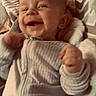 baby, infant, child, smiling, happy, portrait, face, eyes, mouth, hands, fists, striped_clothing, onesie, blanket, bedding, lying_down, indoor, close_up, soft_lighting, adorable