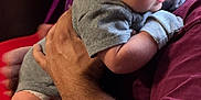 Hunter Dominic Russo joined the competition — help win amazing prizes! baby, infant, adult, arm, holding, grey_clothing, maroon_clothing, tattoo, indoor, closeup, person, skin, face, hand, couch, fabric, curious, newborn, human, portrait