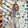 baby, child, infant, smiling, happy, portrait, lying_down, crib, changing_mat, cloud_pattern, mittens, striped_clothing, gray_outfit, nursery, indoor, close_up, face, hands, safe, photography