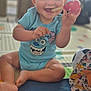 baby, blue_clothing, bright_eyes, cheerful, child, colorful, cute, face, foot, hand, happy, indoor, infant, onesie, patterned_blanket, playmat, playtime, sitting, smiling, toy