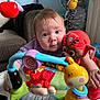 baby, bright_eyes, child, colorful, couch, curious, cute, early_childhood, face, hand, indoor, infant, living_room, person, playtime, plush_toy, smiling, soft_toy, toy, walker
