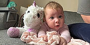 Mollie-Blake joined the competition — help win amazing prizes! baby, blanket, child, clothing, couch, cute, expression, face, furniture, gray, hand, home, indoor, infant, person, pink, portrait, soft_toy, unicorn_plush, white