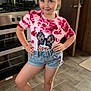 Paige-madison is registered to the contest to win money with this photo: child, girl, tiara, tie_dye_shirt, graphic_tshirt, shorts, sandals, kitchen, stove, floor_tiles, oven, cabinet, paper_towel, utensils, door, smile, pose, standing, indoors, happy