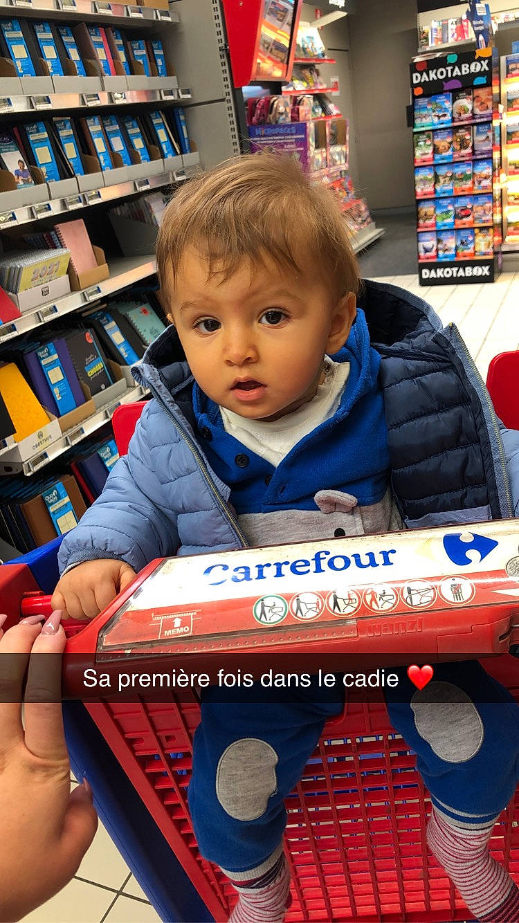 Thymaë participe au concours pour gagner de l'argent avec cette photo : baby, baby_products, baby_toddler_clothing, book, bookcase, bookselling, box, curious, finger, nail, person, play, publication, retail, shelf, shelving, supermarket, thumb, trade