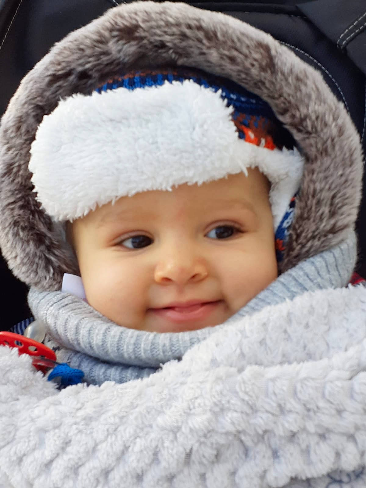 Thymaë participe au concours pour gagner de l'argent avec cette photo : baby, baby_toddler_clothing, bonnet, cheek, child, close_up, comfort, costume_accessory, fur, fur_clothing, headgear, headwear, iris, lip, organ, person, photography, skin, textile, toddler