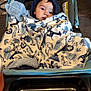 animal_print, baby, blanket, blue, child, comfort, curious, cute, face, floor, hood, indoor, pattern, portrait, seated, soft, stroller, toddler, warm_clothing, wrapped