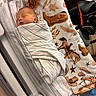 newborn, baby, sleeping, infant, face, portrait, hospital, bassinet, blanket, swaddled, indoors, nursery, medical, crib, peaceful, cowboy_blanket, stars, patterned_fabric, chair, resting
