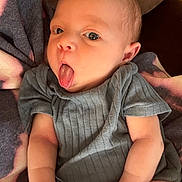 Alaina joined the competition — help win amazing prizes! arms, baby, blanket, clothing, cute, expression, eyes, face, hands, human, indoor, infant, newborn, onesie, playful, portrait, resting, skin, soft_fabric, tongue_out
