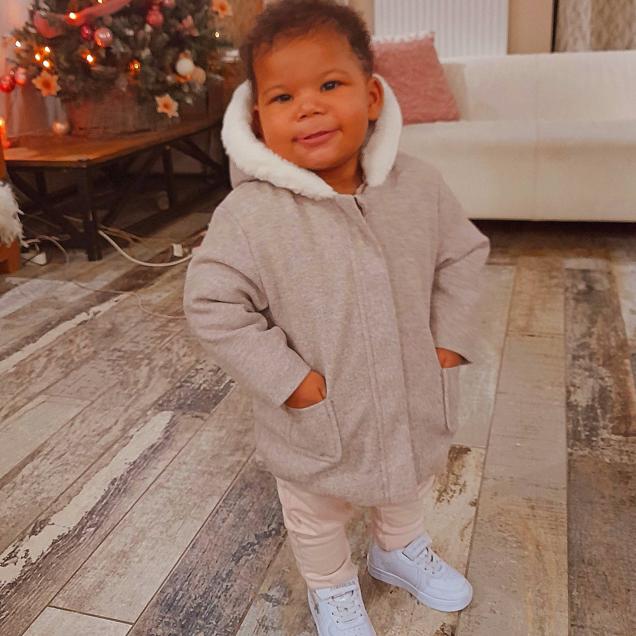 Kataleya participe au concours pour gagner de l'argent avec cette photo : baby_toddler_clothing, child, christmas_tree, event, facial_expression, floor, flooring, happy, head, jacket, joy, outerwear, person, photograph, sitting, sleeve, smile, snapshot, standing, toddler