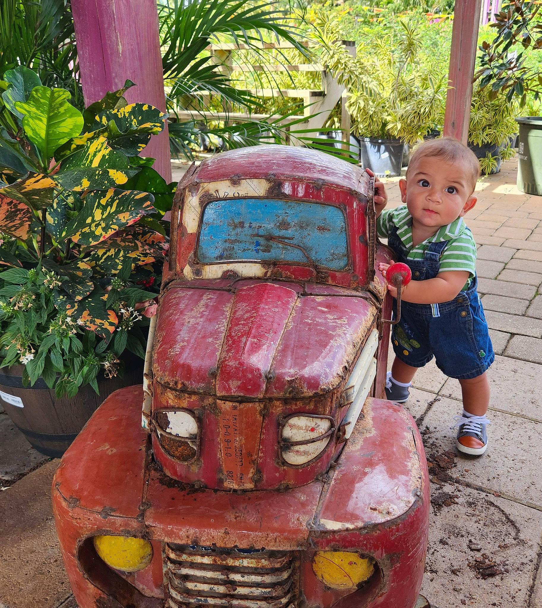 Caleb is registered to the contest to win money with this photo: art, automotive_design, automotive_exterior, automotive_lighting, automotive_tire, bumper, car, classic, grass, grille, headlamp, hood, land_vehicle, motor_vehicle, person, plant, shorts, toddler, tree, vehicle