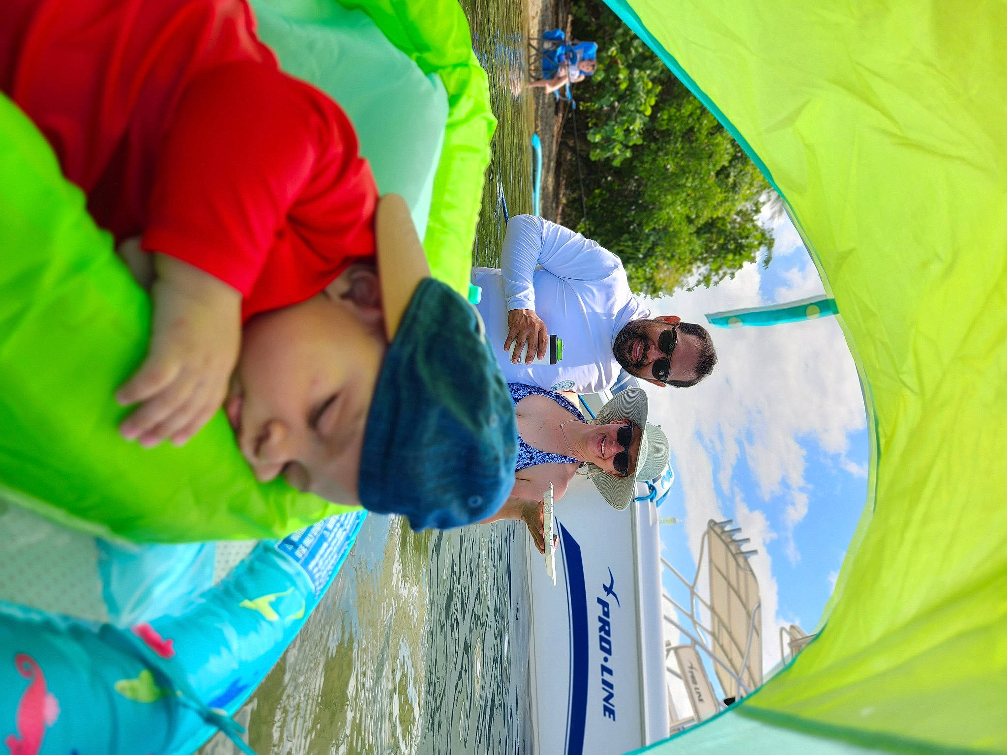 Caleb is registered to the contest to win money with this photo: child, event, fun, grass, happy, hat, headwear, joy, lake, landscape, leisure, person, plant, play, recreation, shade, t_shirt, tent, toddler, tree