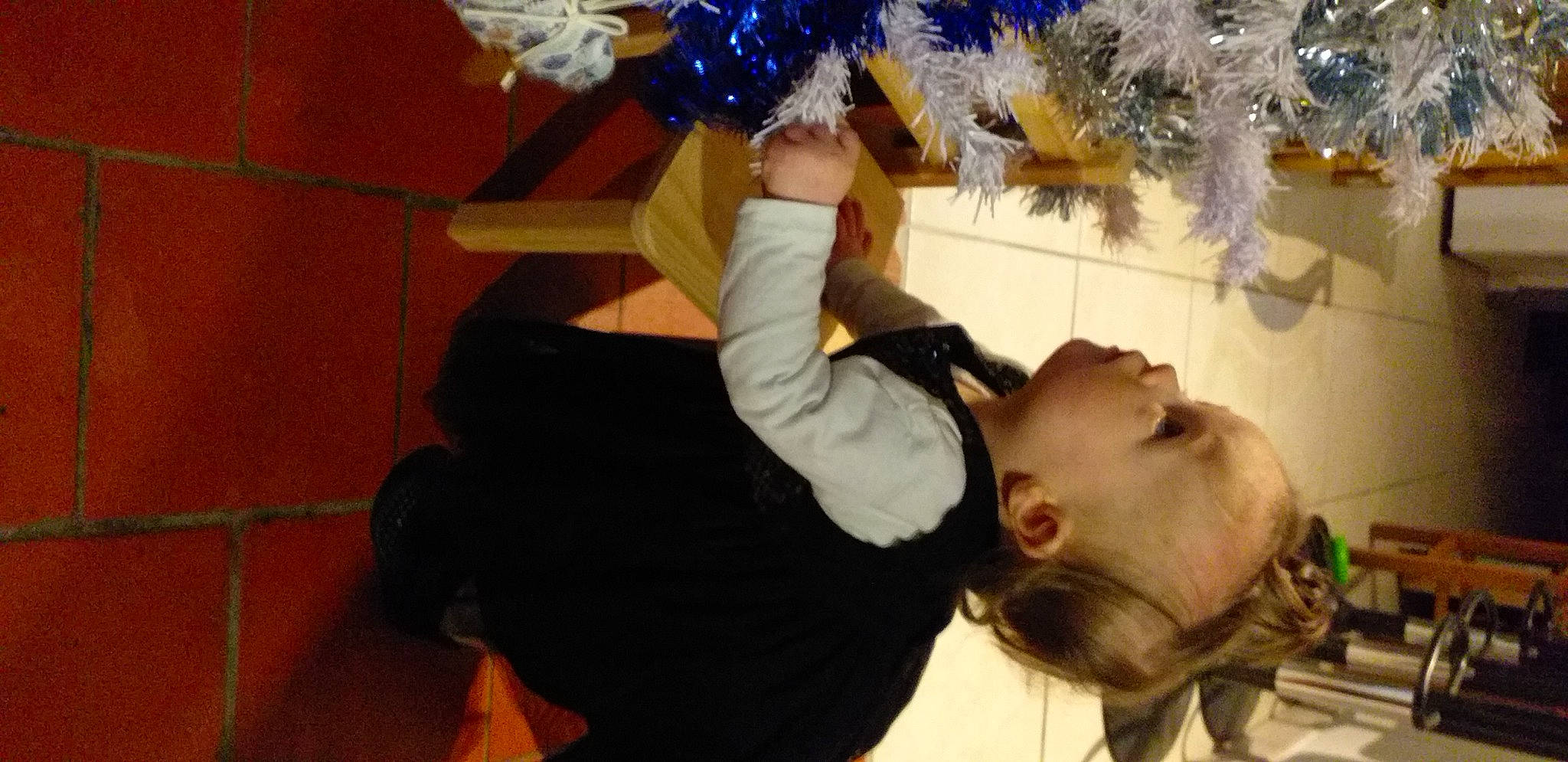 Lyna participe au concours pour gagner de l'argent avec cette photo : child, christmas, christmas_decoration, christmas_eve, christmas_ornament, christmas_tree, event, eyelash, fun, fur, gesture, happy, holiday, interior_design, person, plant, room, suit, toddler, tradition