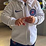Alessio a rejoint le concours — aidez-le/la à gagner de superbes lots ! child, toddler, smiling, indoor, person, clothing, hoodie, jacket, sportswear, nike, paris_saint_germain, pants, socks, standing, blond_hair, portrait, happy, cute, young, floor