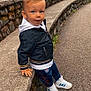 Alessio participe au concours pour gagner de l'argent avec cette photo : toddler, child, blue_eyes, jacket, hoodie, pants, sneakers, stone_wall, sidewalk, outdoor, casual, standing, curious, urban, young_child, fashion, person, street, daytime, leisure