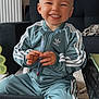 adidas, casual, child, clothing, couch, cute, face, furniture, happy, home, indoor, living_room, pen, person, portrait, sitting, smiling, toddler, toy, tracksuit