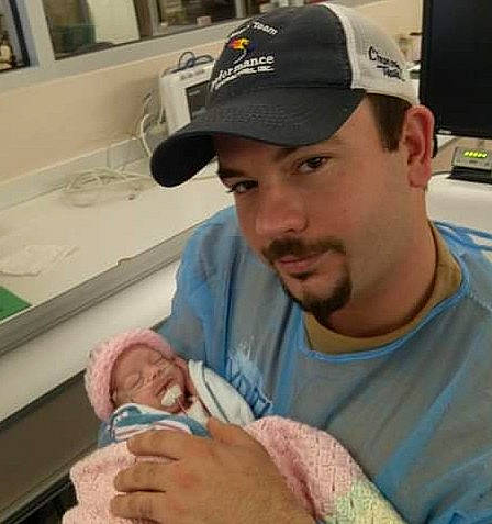 Lexi is registered to the contest to win money with this photo: arm, baby, baseball_cap, beard, cap, child, cricket_cap, ear, event, gesture, hand, headwear, health_care, mouth, muscle, person, room, service, smile, t_shirt