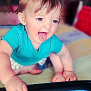 Benji joined the competition — help win amazing prizes! baby, child, tongue_out, crawling, blue_shirt, hands, feet, indoor, playful, smiling, face, person, young_child, happy, cute, skin, hair, expression, furniture, floor