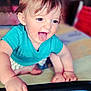 baby, child, tongue_out, crawling, blue_shirt, hands, feet, indoor, playful, smiling, face, person, young_child, happy, cute, skin, hair, expression, furniture, floor