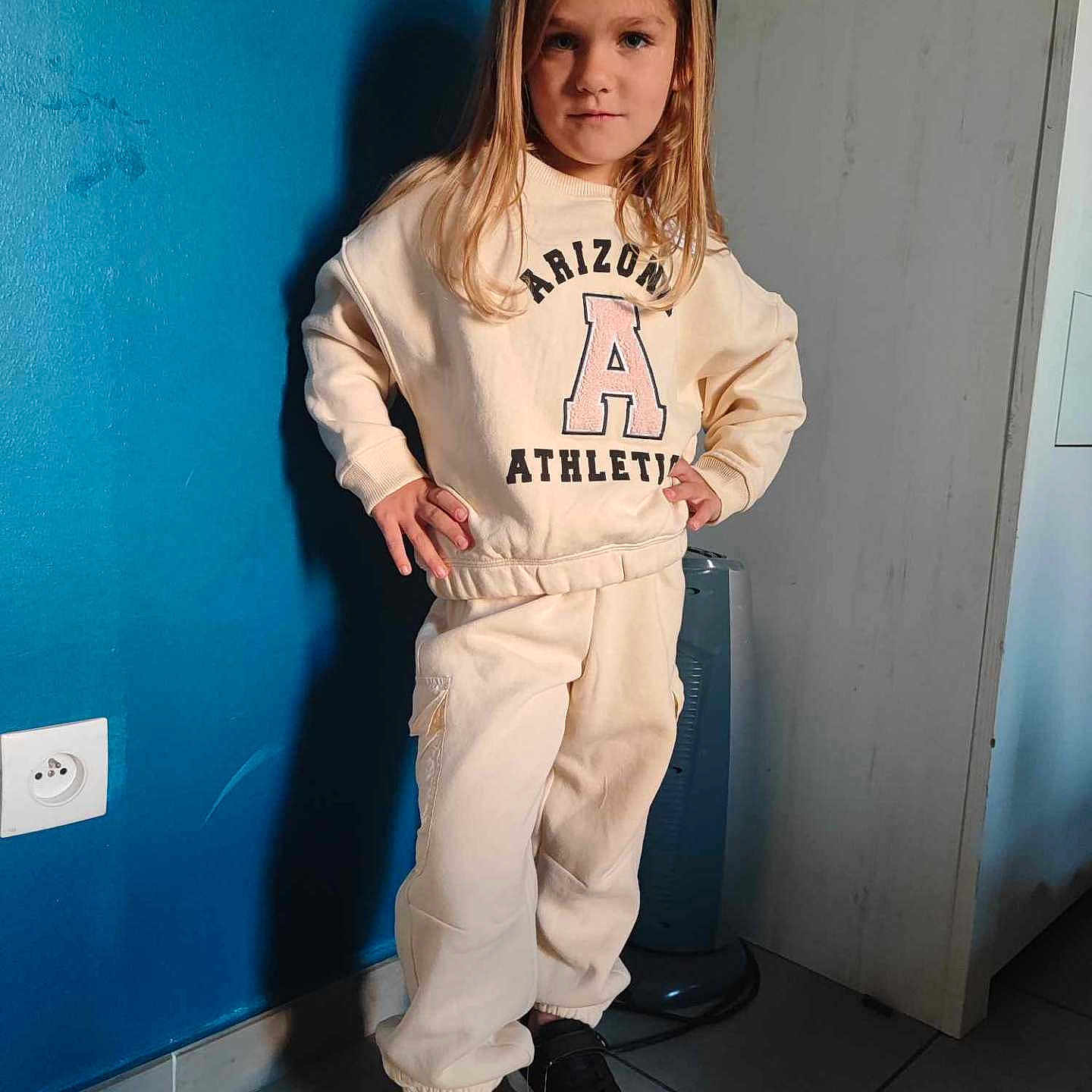 Rosalie participe au concours pour gagner de l'argent avec cette photo : blonde, child, clothing, coat, female, footwear, girl, hair, jeans, knitwear, longsleeve, number, pants, person, shoe, sleeve, standing, sweater, symbol, text
