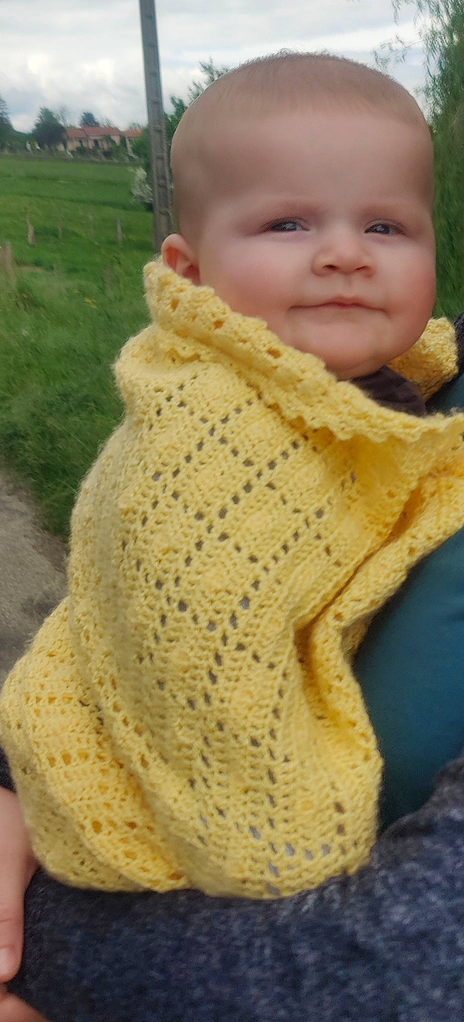 Liam participe au concours pour gagner de l'argent avec cette photo : baby, baby_toddler_clothing, crochet, fashion_accessory, finger, fur, grass, happy, headgear, knit_cap, pattern, person, sitting, skin, sleeve, smile, thumb, toddler, wool, woolen
