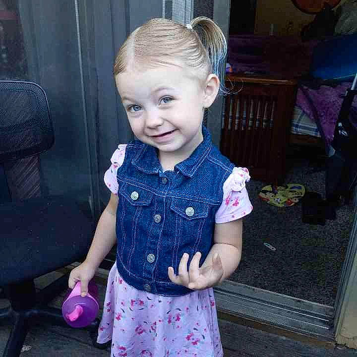 April is registered to the contest to win money with this photo: baby_toddler_clothing, chair, cheek, child, dress, electric_blue, eye, face, fun, hair, hairstyle, happy, head, iris, joy, pattern, person, pink, purple, sleeve