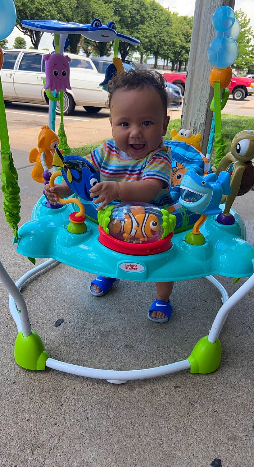 Marcel is registered to the contest to win money with this photo: baby, baby_products, baby_toddler_clothing, blue, car, child, city, fun, grass, green, happy, leisure, person, recreation, riding_toy, smile, tire, toddler, toy, vehicle
