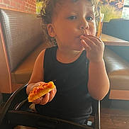 Amante joined the competition — help win amazing prizes! child, toddler, pizza, food, high_chair, curly_hair, black_shirt, indoor, restaurant, table, booth, seat, brown_hair, eating, person, cute, casual, snack, young_child, dining