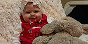 Vyctoire participe au concours pour gagner de l'argent avec cette photo : baby, bow, red_clothing, plush_toy, bunny, blanket, smiling, indoors, child, cute, soft_texture, cozy, sitting, person, headband, toy, happy, infant, warm, comfort
