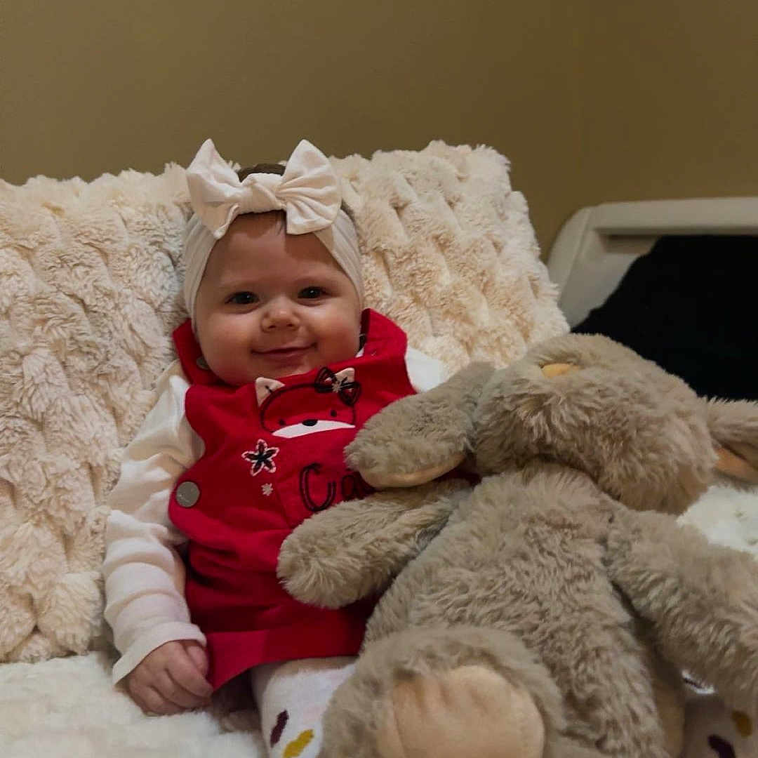 Vyctoire participe au concours pour gagner de l'argent avec cette photo : baby, blanket, bow, bunny, child, comfort, cozy, cute, happy, headband, indoors, infant, person, plush_toy, red_clothing, sitting, smiling, soft_texture, toy, warm