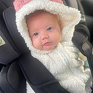 Mali-Rae is registered to the contest to win money with this photo: baby, infant, car_seat, hood, white_jacket, pink_detail, face, eyes, clothing, child, seat_belt, soft_texture, cute, portrait, indoor, person, warm_clothing, closeup, newborn, babywear